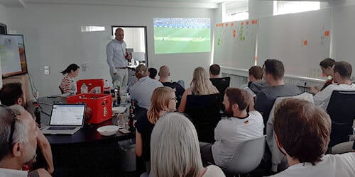 Mitarbeiter schauen gemeinsam ein Spiel der Fußball WM 2018.