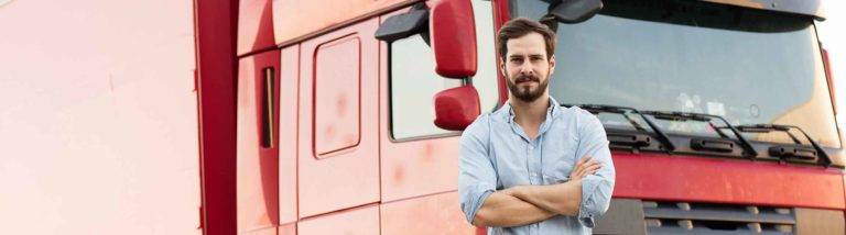 Fahrer steht vor LKW mit der Frage, ob man als LKW-Fahrer seinen Kollegen bei der Polizei melden sollte, wenn man den Verdacht hat, dass der Fahrer-Kollege Alkohol getrunken hat.