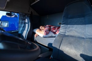 Truck driver sleeps in driver's cab