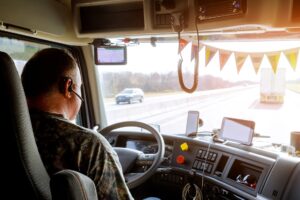 Fahrer in der Kabine eines großen modernen Lkw auf der Landstraße