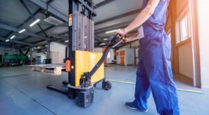 Worker with forklift in the warehouse