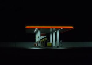 Beleuchtete Tankstelle bei Nacht. Isoliert auf dunklem Hintergrund.