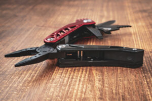 Steel multi tool on the wooden background