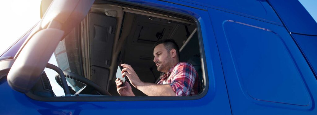 Lkw-Fahrer, der am Steuer sitzt und ein Tablet benutzt