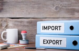 Exporting across EEA borders. Import and Export. Two binders on desk in the office. Business background