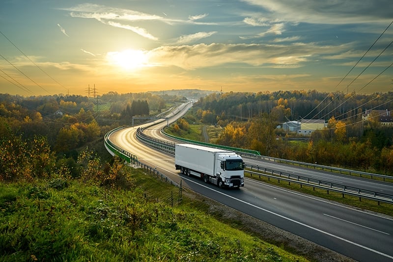 How digital transformation drives sustainability in logistics, truck before sunset