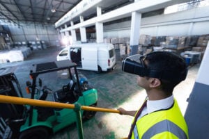 Business man with VR glasses observing warehouse as symbol for gaming and virtual reality in logistics