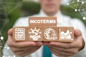 Man holding building blocks with Incoterms written on them into the camera for the article on Incoterms 2020