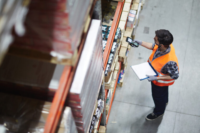 Warehouse Worker with scanner making review of goods in warehouse